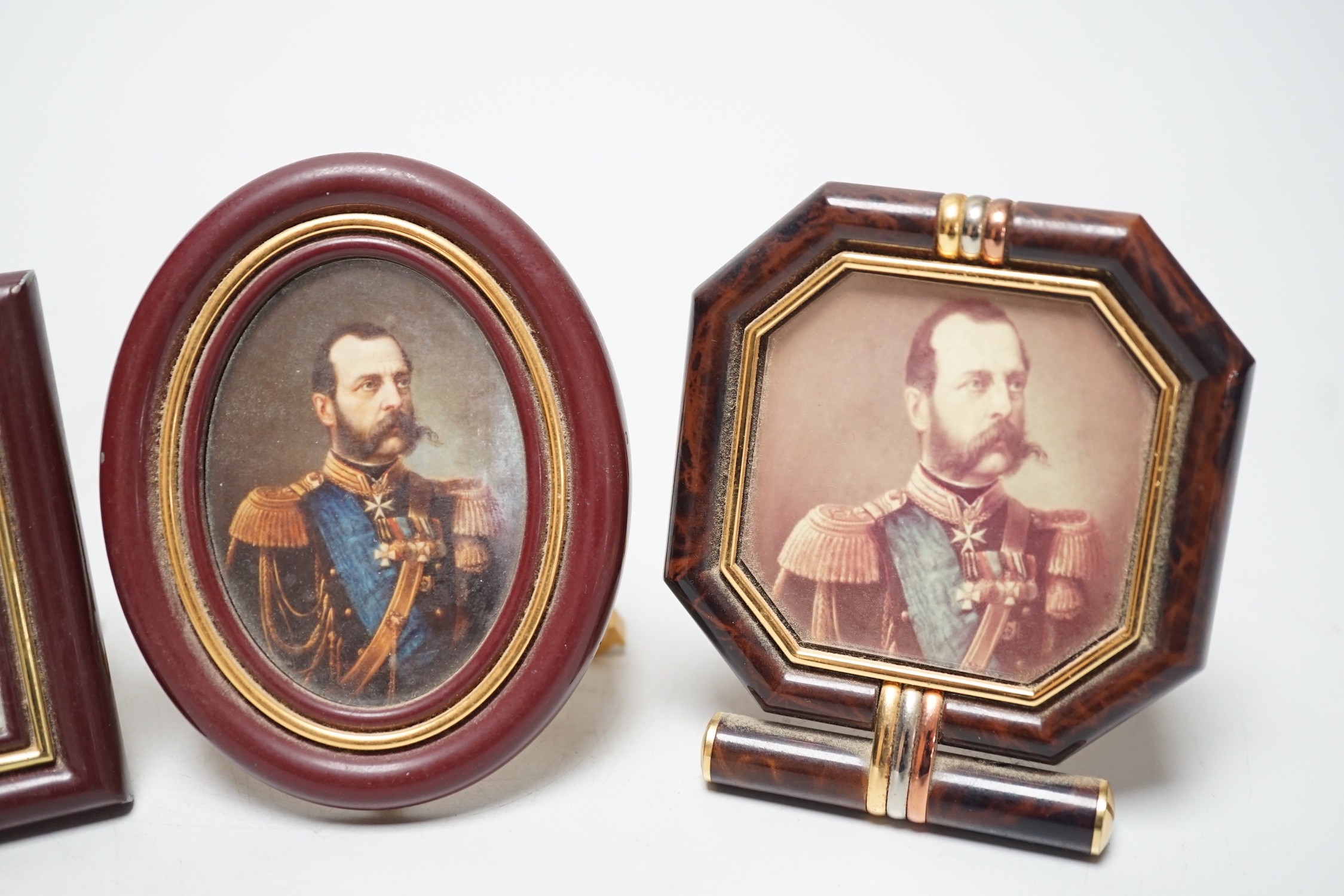 A Cartier travelling alarm timepiece and two Must de Cartier miniature frames